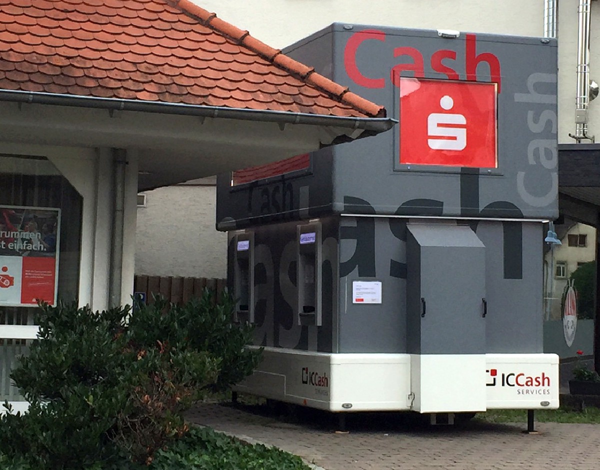Mobiler Geldautomatenanhänger von IC Cash vor einer Sparkassenfiliale
