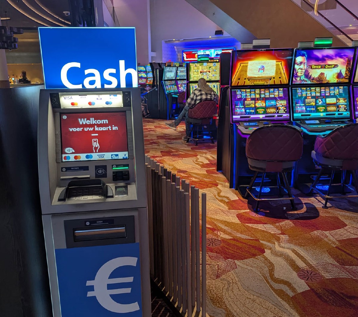 Geldautomat neben Spielautomaten in einem Casino